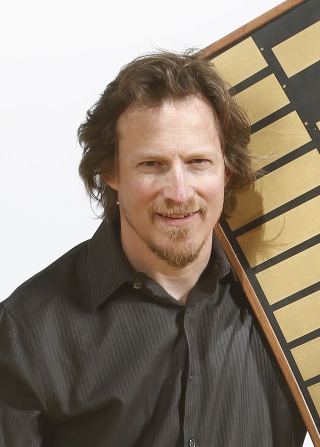 Portrait of Joel Davel with a Marimba Lumina over his shoulder